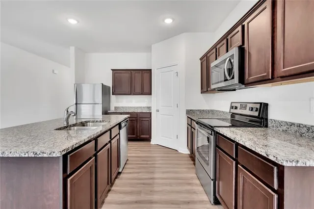 a kitchen with stainless steel appliances granite countertop a sink stove and cabinets