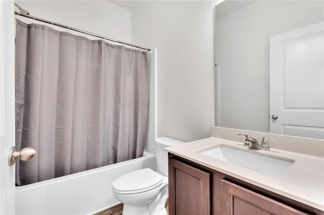 a bathroom with a granite countertop sink and a toilet