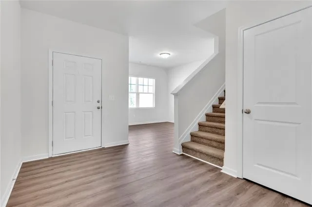 a view of a room with wooden floor and entryway