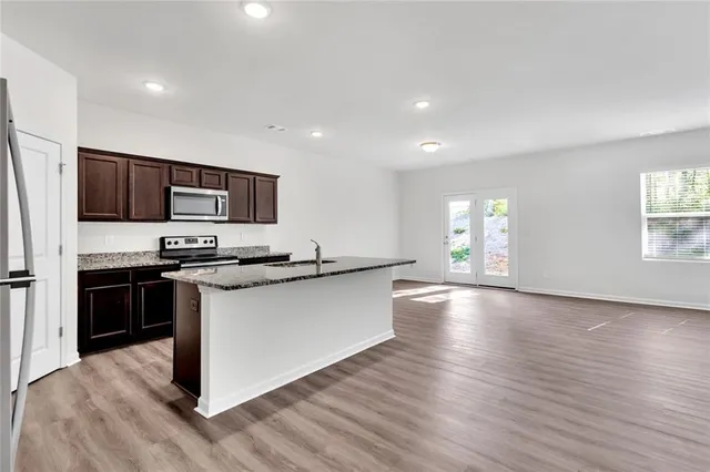 a kitchen with stainless steel appliances granite countertop a stove a sink and a refrigerator