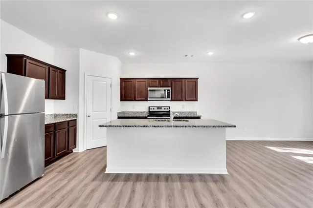 a kitchen with stainless steel appliances wooden floors and wooden cabinets