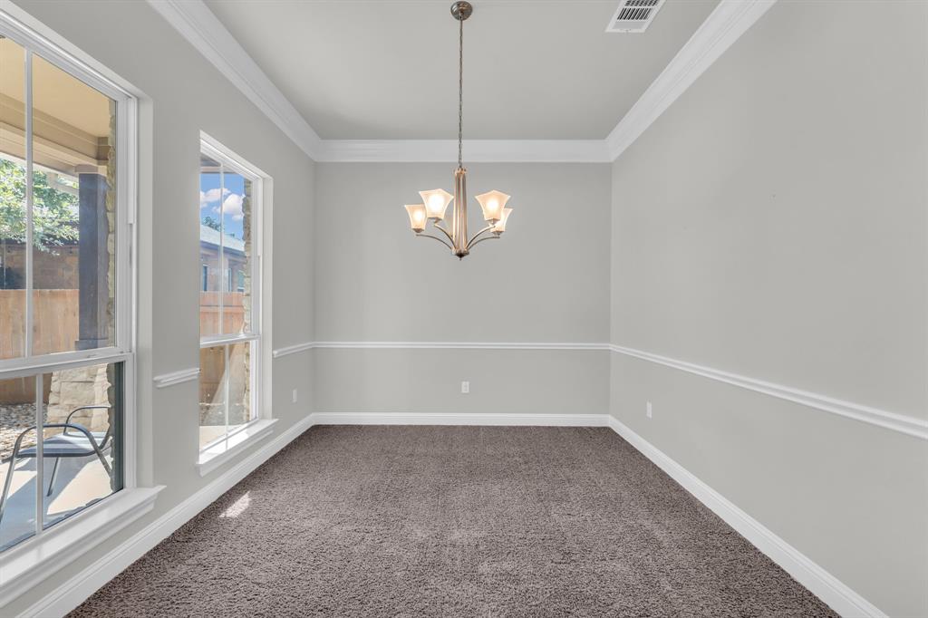 110 Magona Trail Georgetown, TX 78628 - Photo 9 of 38 A classic chandelier illuminates this spacious, carpeted dining room.