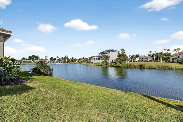 an aerial view of ocean and residential houses with outdoor space