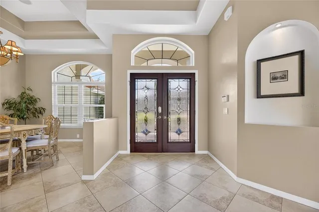 a view of a dining room with furniture a chandelier and window