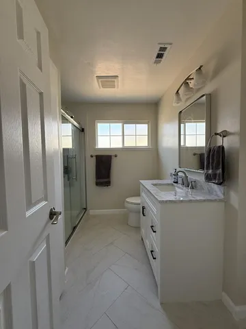 a spacious bathroom with a granite countertop sink a mirror and shower