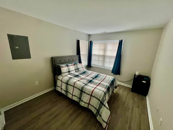 a bedroom with a bed and wooden floor