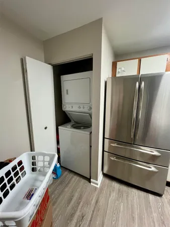 a kitchen with a refrigerator and white cabinets
