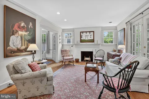 a living room with furniture a chandelier and a flat screen tv