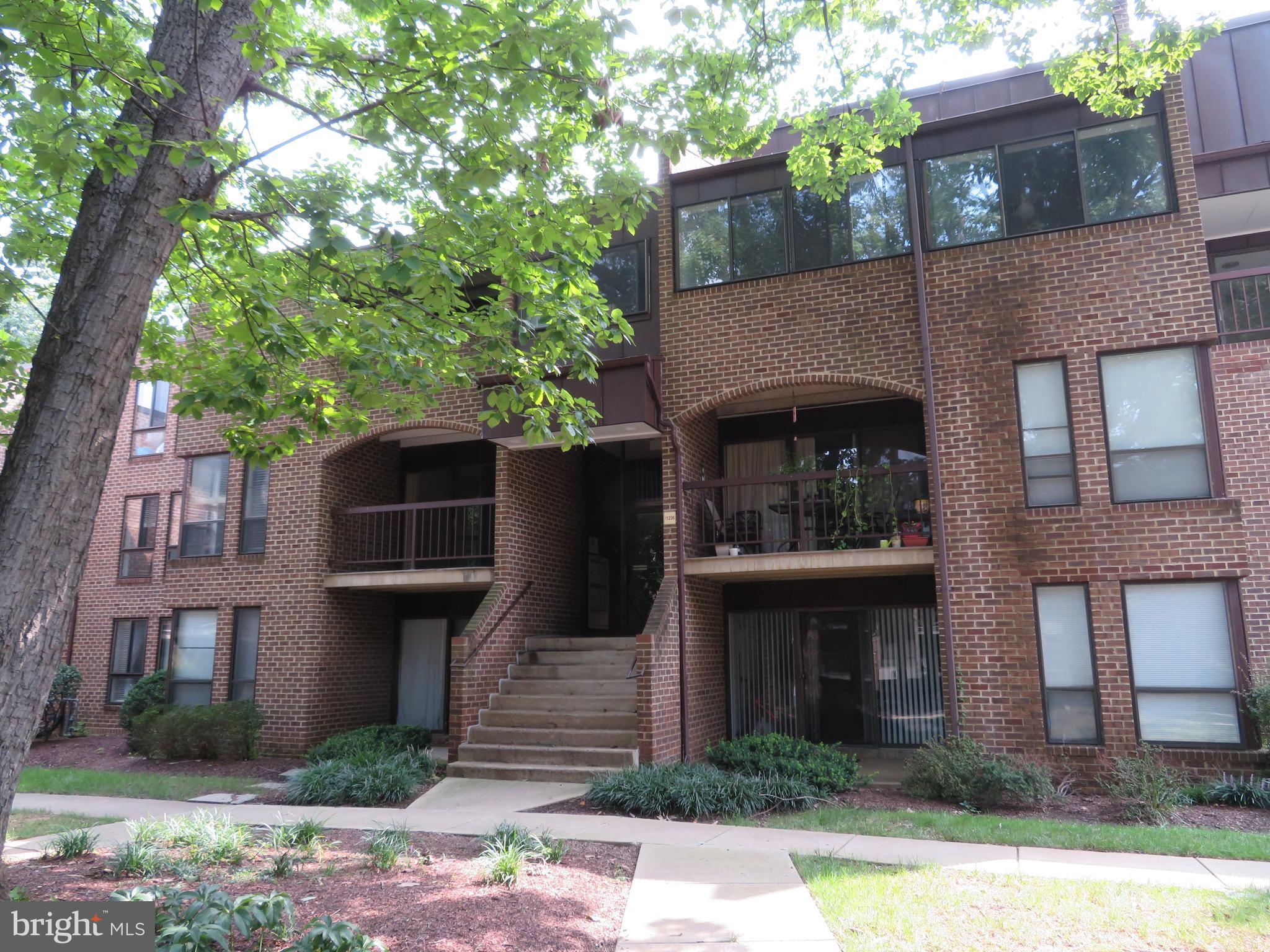 11236 Chestnut Grove Square, Unit 261 Reston, VA 20190 - Photo 1 of 30 a front view of a house with garden