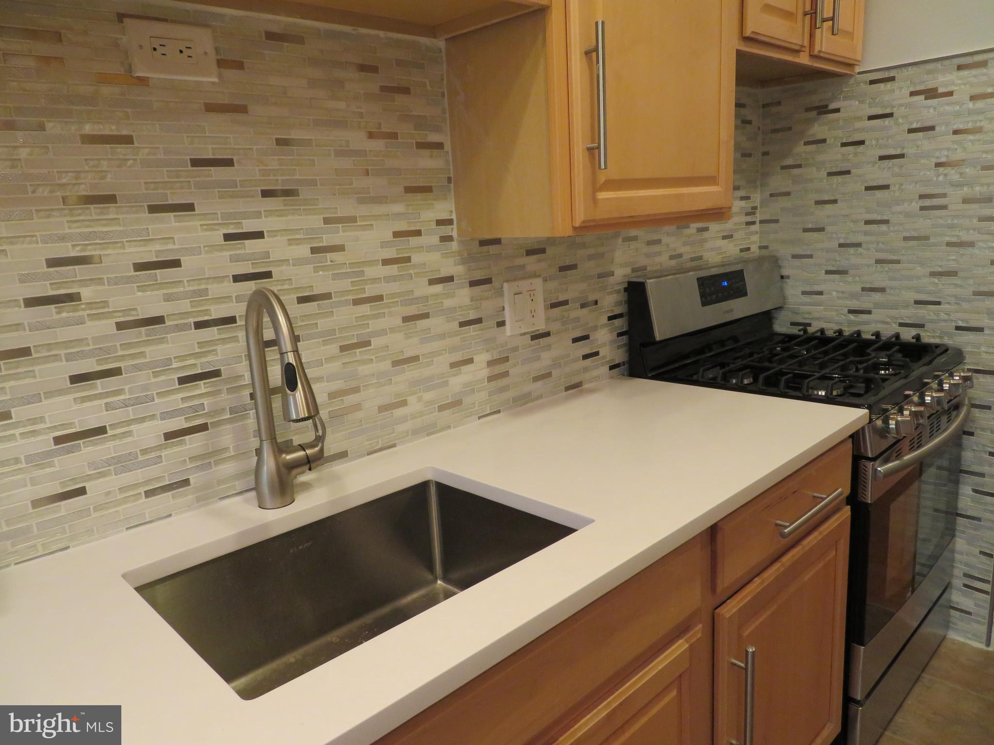 11236 Chestnut Grove Square, Unit 261 Reston, VA 20190 - Photo 14 of 30 a kitchen with a sink a stove and cabinets