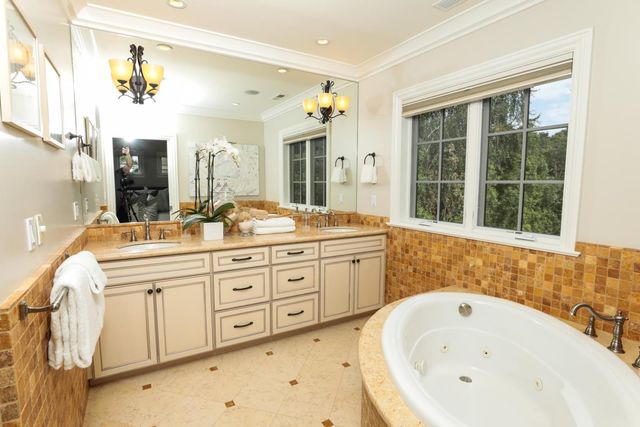 a spacious bathroom with a granite countertop sink and a bathtub