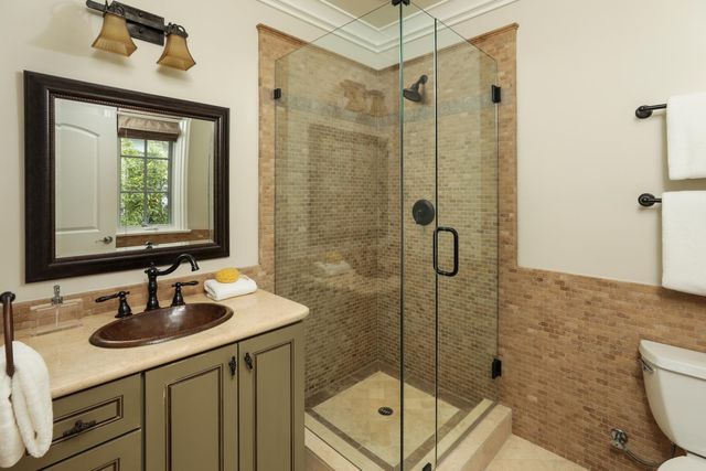 a bathroom with a sink a toilet and shower