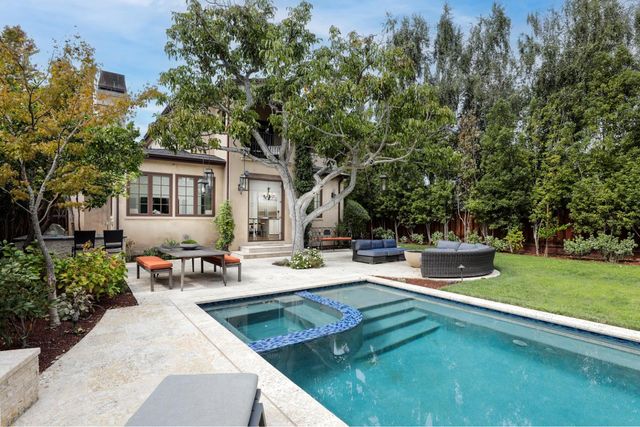 a view of a house with backyard and sitting area