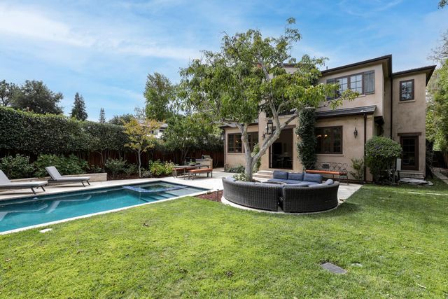 a view of a backyard with swimming pool and fire pit