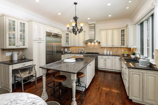 a kitchen with a sink a kitchen island and stainless steel appliances