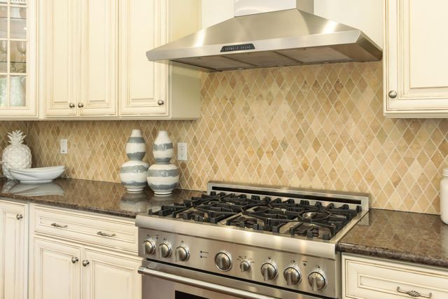 a stove top oven sitting inside of a kitchen