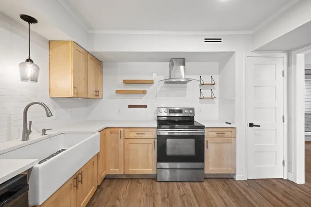 a kitchen with cabinets wooden floor and stainless steel appliances