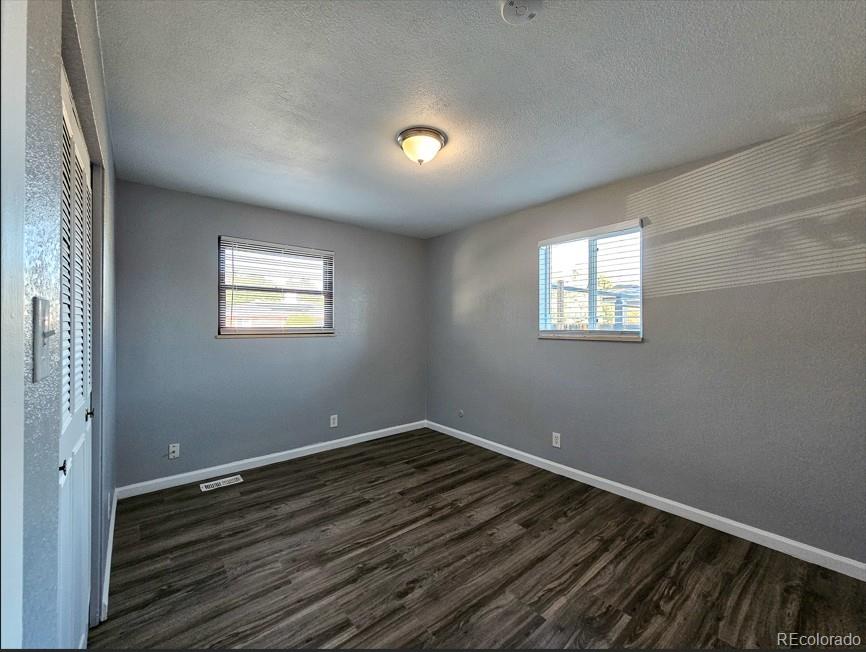 5542 Scranton Street Denver, CO 80239 - Photo 12 of 36 a view of wooden floor and chandelier in a room