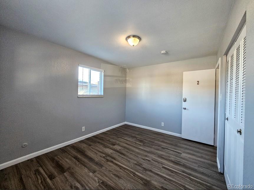 5542 Scranton Street Denver, CO 80239 - Photo 15 of 36 a view of an empty room with wooden floor and a window