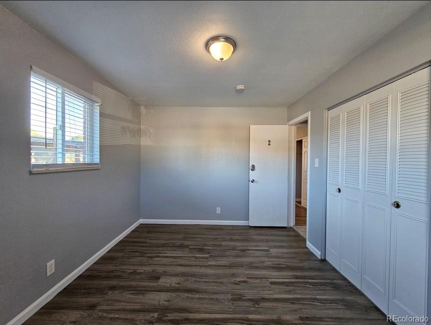 5542 Scranton Street Denver, CO 80239 - Photo 16 of 36 a view of an empty room with wooden floor and window