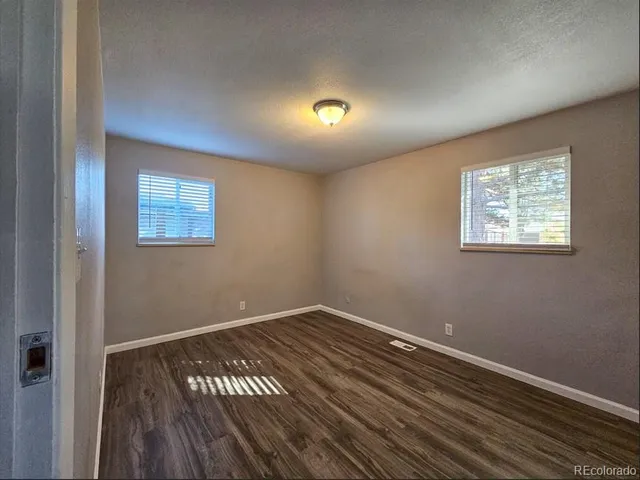 a view of a room with wooden floor and windows