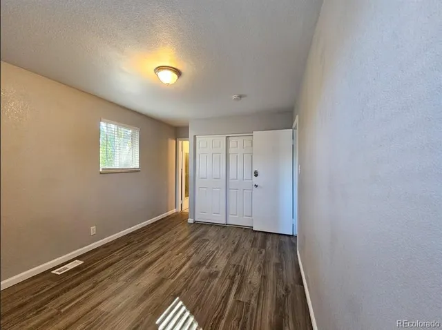 a view of a room with wooden floor and window