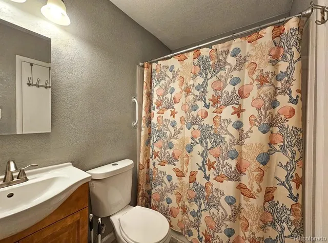 a white toilet sitting next to a shower curtain