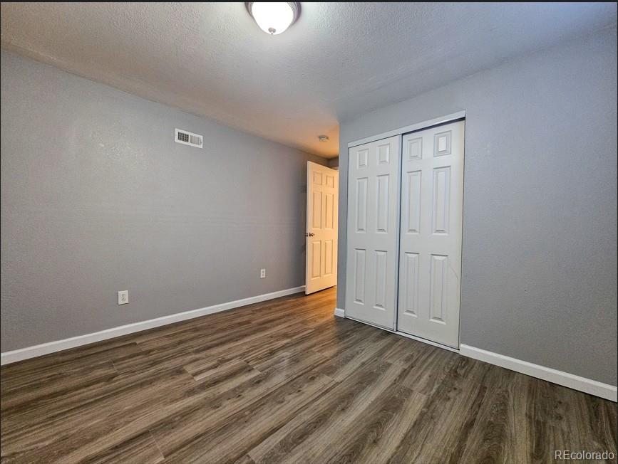 5542 Scranton Street Denver, CO 80239 - Photo 34 of 36 a view of an empty room with wooden floor