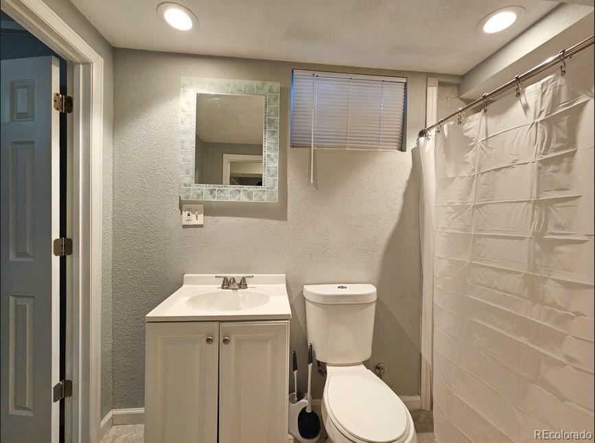 5542 Scranton Street Denver, CO 80239 - Photo 35 of 36 a bathroom with a toilet sink and shower