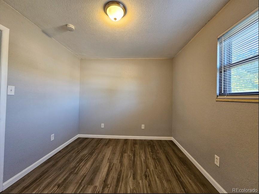 5542 Scranton Street Denver, CO 80239 - Photo 9 of 36 a view of room with window and wooden floor