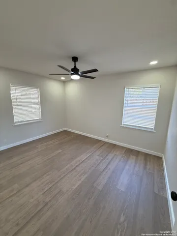a view of a room with wooden floor and fan