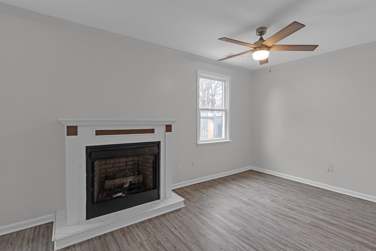 4251 Riviera Drive Memphis, TN 38108 - Photo 6 of 16 wooden floor fireplace and windows in an empty room