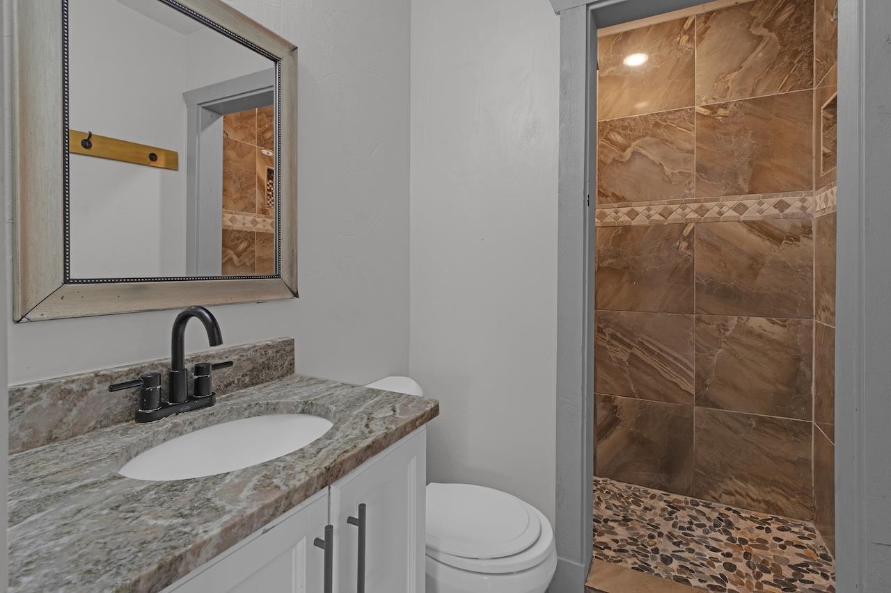 4251 Riviera Drive Memphis, TN 38108 - Photo 9 of 16 a bathroom with a granite countertop sink a mirror and a shower