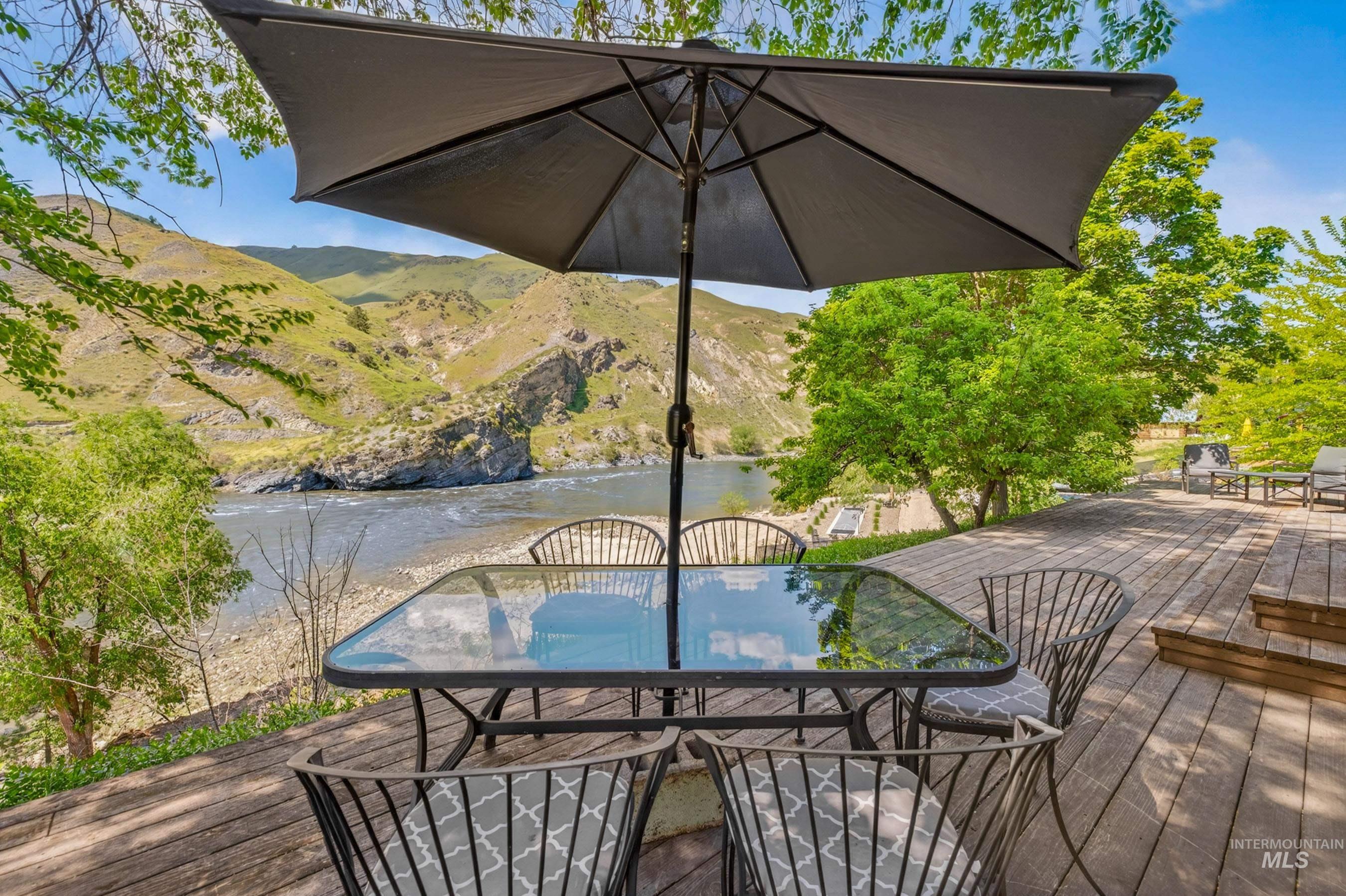151 Cow Creek Road Lucile, ID 83542 - Photo 4 of 50 Expansive wood-finish decking featuring a riverfront setting and mountain backdrop