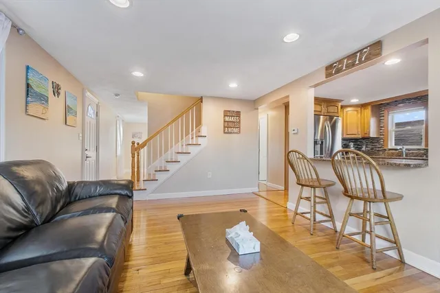 a living room with furniture and a dining table with wooden floor