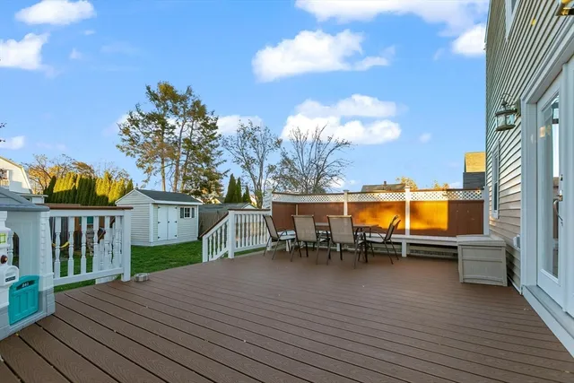 a view of a roof deck with table and chairs a barbeque with wooden floor and fence