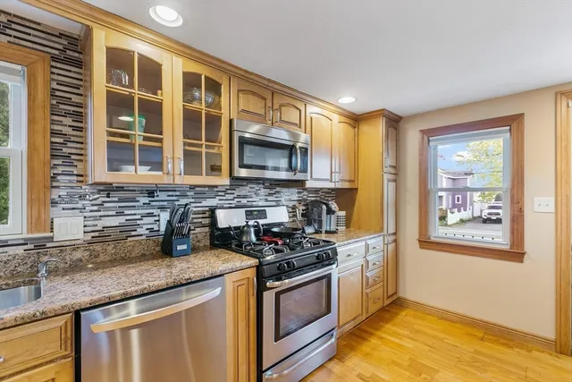 a kitchen with stainless steel appliances granite countertop a stove a sink and a microwave