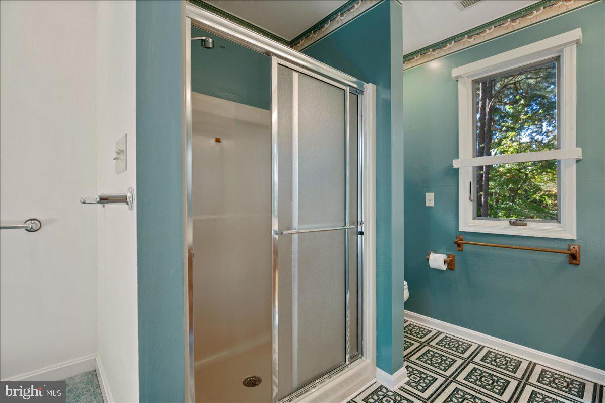 13140 Soundings Road Lusby, MD 20657 - Photo 60 of 81 a bathroom with a glass shower door and a window