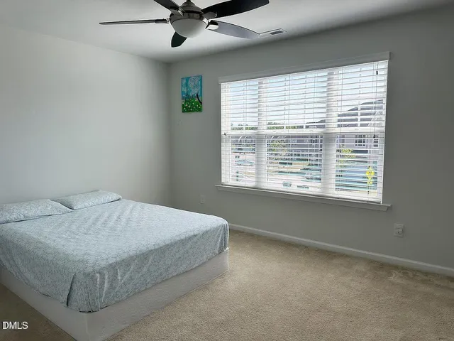 a bathroom with a granite countertop toilet a sink a mirror and shower curtain