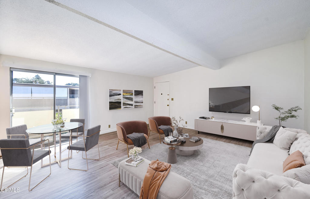 a living room with furniture wooden floor and a large window
