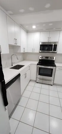 a kitchen with stainless steel appliances a sink a stove a microwave and cabinets