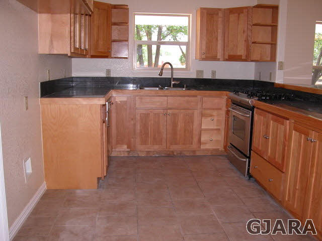 7715 Dover Road Delta, CO 81416 - Photo 8 of 33 a kitchen with granite countertop a sink stove and cabinets