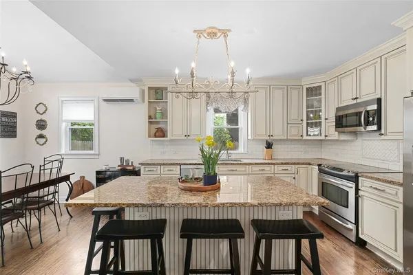 a kitchen with stainless steel appliances granite countertop a dining table chairs and granite counter tops