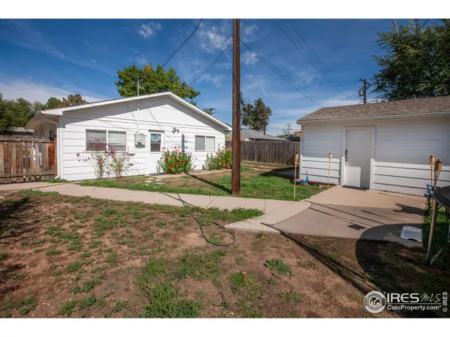 a view of a white house with a yard