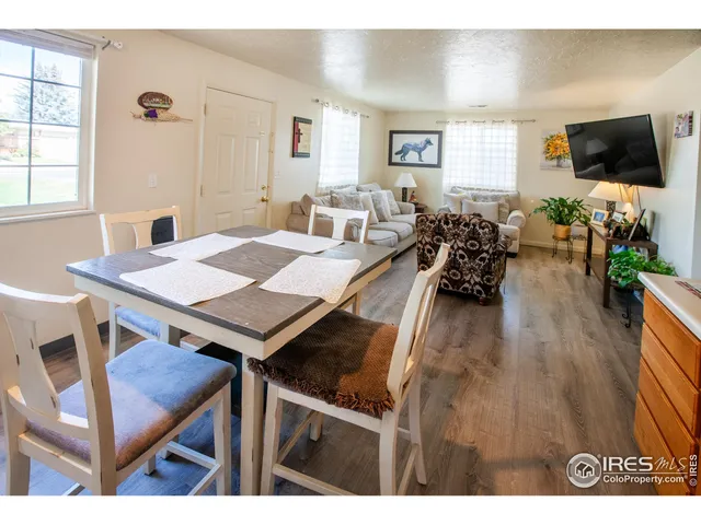 a living room with furniture a flat screen tv and a large window