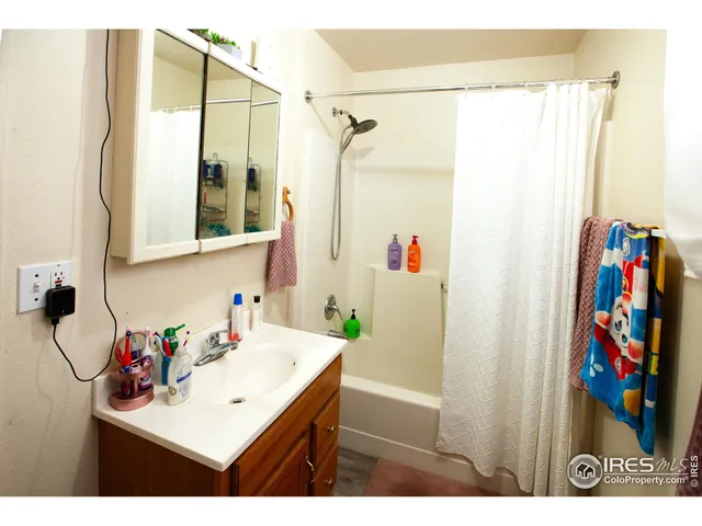 a bathroom with a sink mirror and a shower curtain