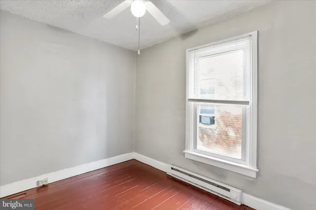 a view of a room with wooden floor and ceiling fan