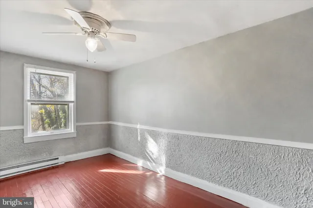 a view of an empty room with wooden floor