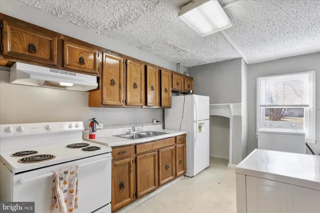 a kitchen with a sink a stove cabinets and refrigerator