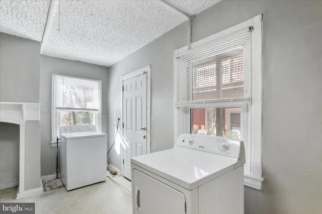 an empty room with wooden floor ceiling fan and windows